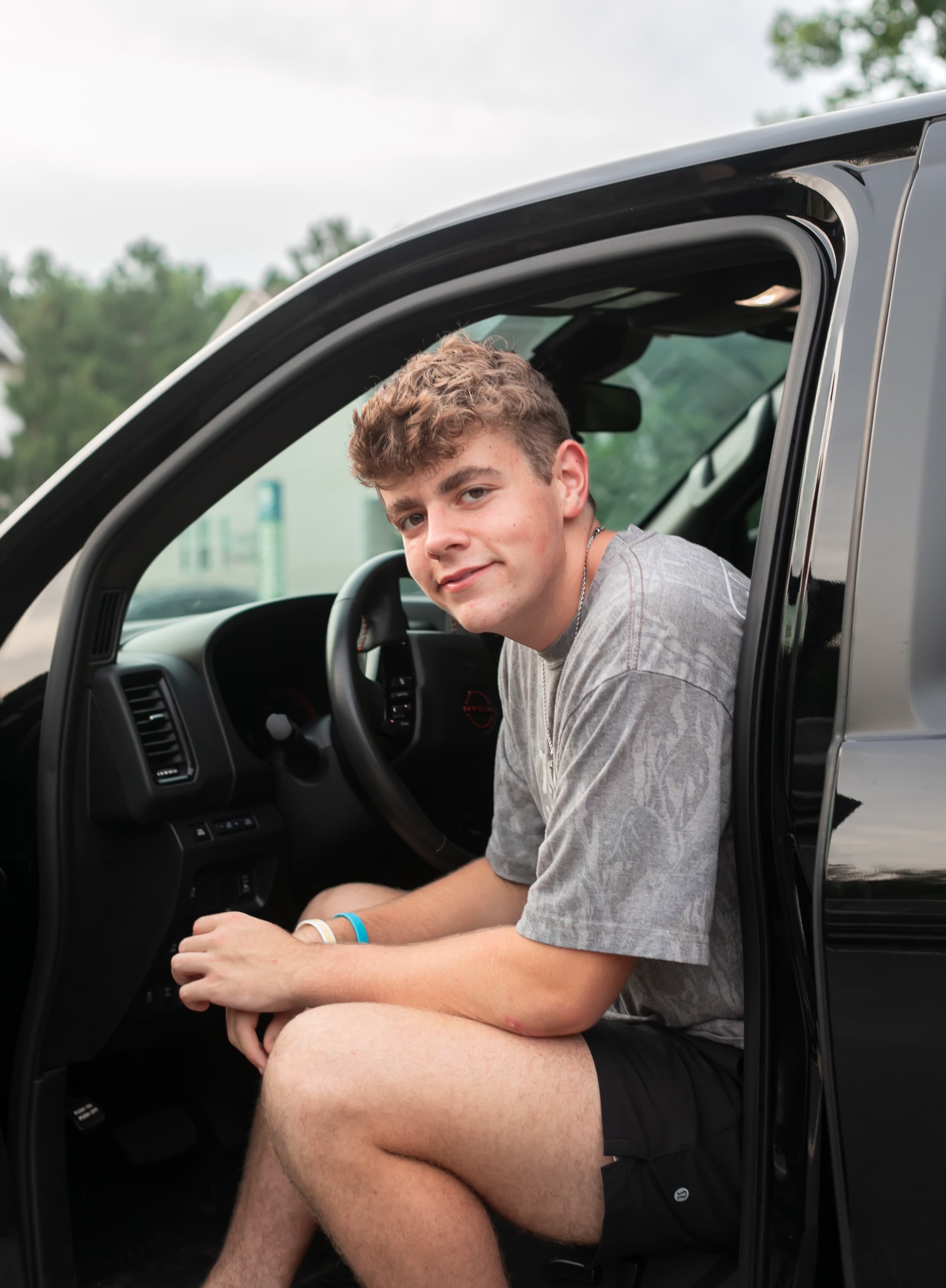 High school senior portrait seated in the driver's seat