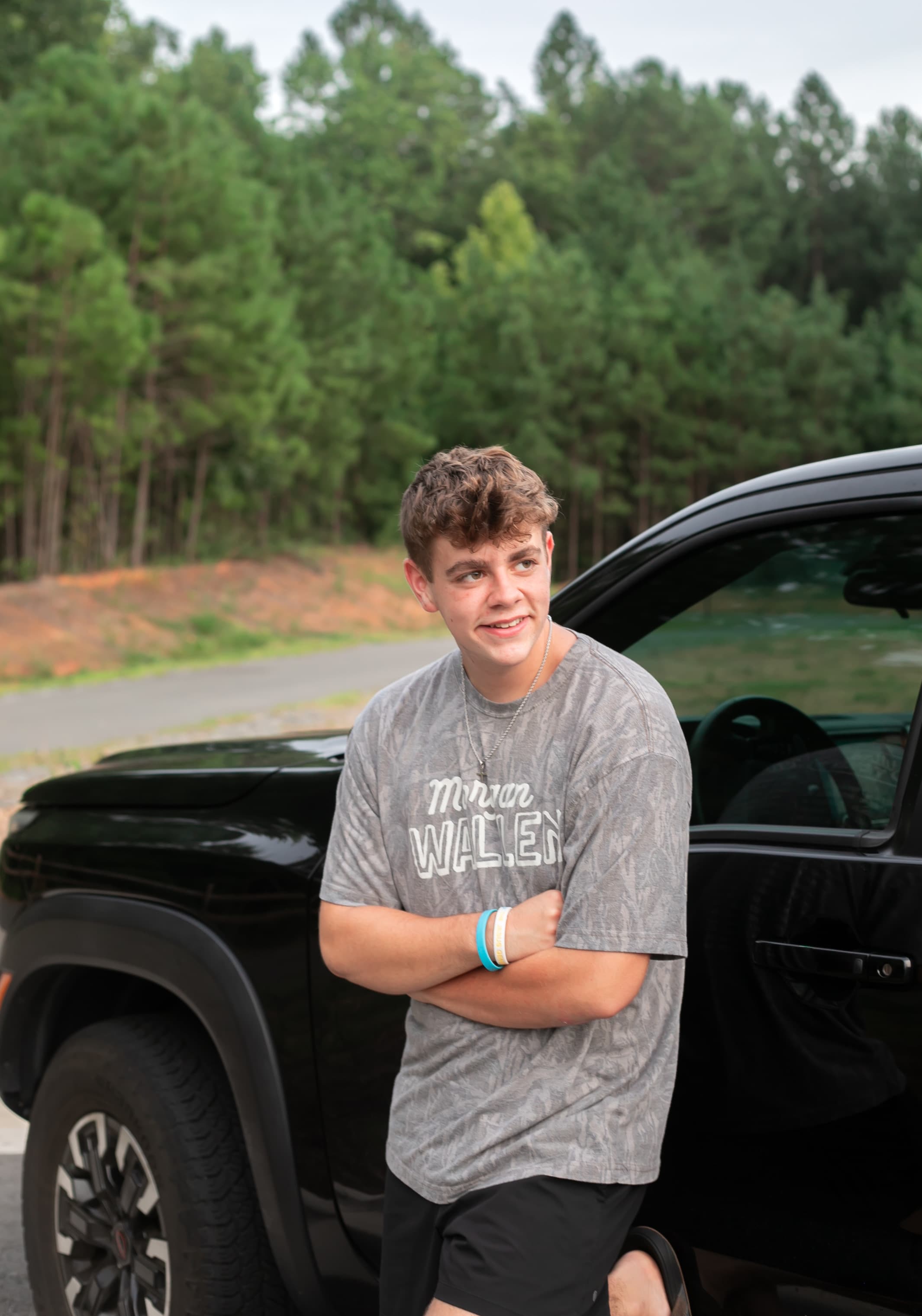 High school senior portrait leaning against his truck